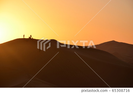 A Sunset View with Tourists Silhouettes on Sahara's Dunes A Sunset View with Tourists Silhouettes on Sahara's Dunes 65308716