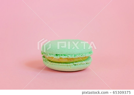Green macaron on pink background Green macaron on pink background 65309375