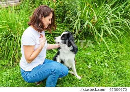 Smiling young attractive woman playing with cute 65309670