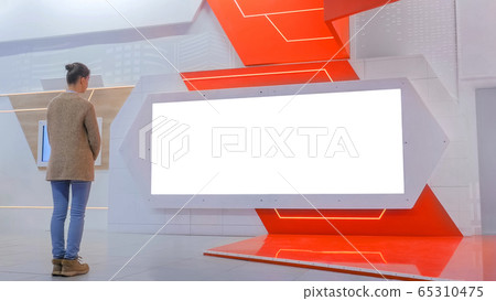Woman looking at blank large interactive wall display - white screen concept 65310475