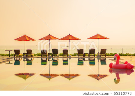 Beautiful sunrise around with umbrella and chair outdoor swimming pool Beautiful sunrise around with umbrella and chair outdoor swimming pool 65310773