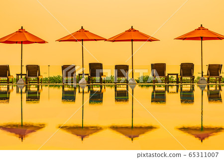 Beautiful sunrise around with umbrella and chair outdoor swimming pool Beautiful sunrise around with umbrella and chair outdoor swimming pool 65311007