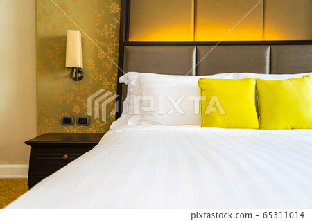 Pillow and blanket on bed with light lamp decoration interior Pillow and blanket on bed with light lamp decoration interior 65311014