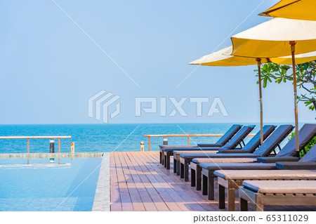 Beautiful empty chair umbrella around outdoor swimming pool in hotel resort for travel Beautiful empty chair umbrella around outdoor swimming pool in hotel resort for travel 65311029