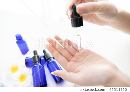 Hand of woman with bottle of aroma oil Hand of woman with bottle of aroma oil 65311550