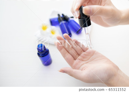 Hand of woman with bottle of aroma oil Hand of woman with bottle of aroma oil 65311552