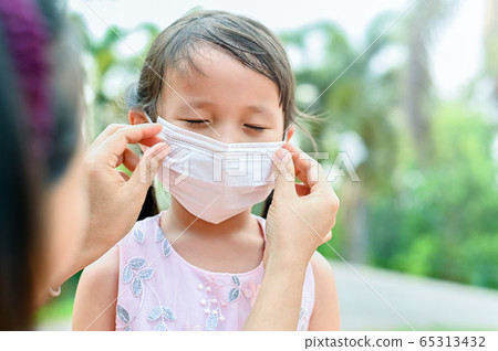 Mother is wearing a cloth mask for little girl protect herself from Coronavirus when child leave the house mom is wearing mask on her nose for safety outdoor activity,illness or Air pollution Mother is wearing a cloth mask for little girl protect herself from Coronavirus when child leave the house mom is wearing mask on her nose for safety outdoor activity,illness or Air pollution 65313432
