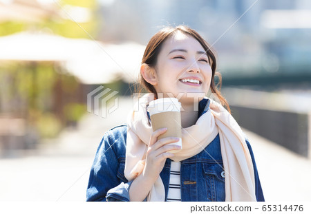 Lifestyle A woman walking with a coffee cup Lifestyle A woman walking with a coffee cup 65314476