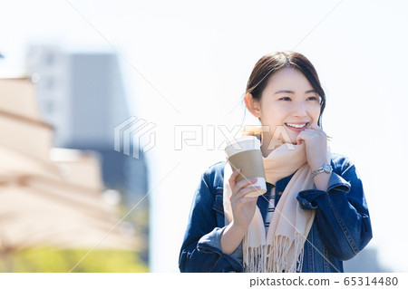 Lifestyle A woman walking with a coffee cup Lifestyle A woman walking with a coffee cup 65314480