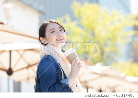 Lifestyle A woman walking with a coffee cup Lifestyle A woman walking with a coffee cup 65314493