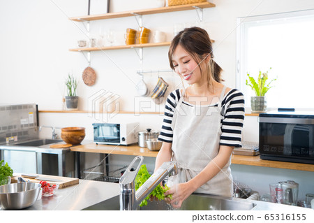 在廚房裡做飯的年輕女子 在廚房裡做飯的年輕女子 65316155