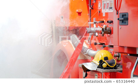 Firefighter fighting with flame using fire hose Firefighter fighting with flame using fire hose 65316440