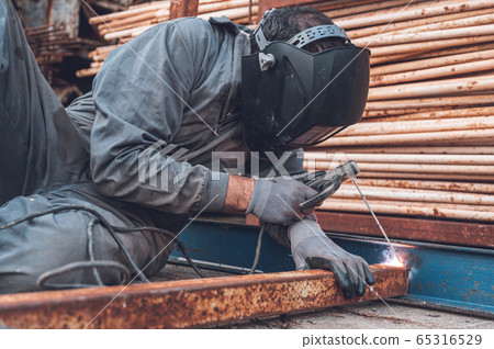 Welding work, Man Welding in Workshop. Metalwork and Sparks. Construction and Industrial concept. Welding work, Man Welding in Workshop. Metalwork and Sparks. Construction and Industrial concept. 65316529