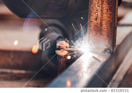 Close-up of the welding process of two metal parts. Industrial background. 65316531