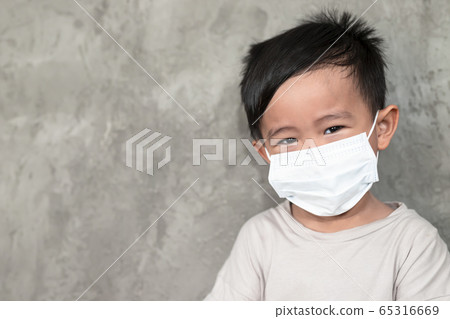 A boy wearing medical face mask for pollution or coronavirus,child itchy eyes and nose, Kid scratching nose while wearing protection mask. A boy wearing medical face mask for pollution or coronavirus,child itchy eyes and nose, Kid scratching nose while wearing protection mask. 65316669