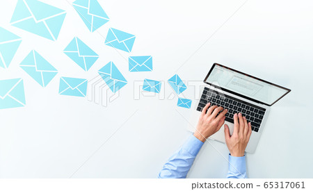 Male hands sending and receiving email on a laptop. White background with numerous mail icons. 65317061