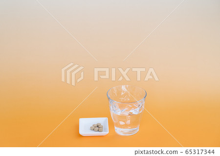 Water and medicine poured into a glass 65317344
