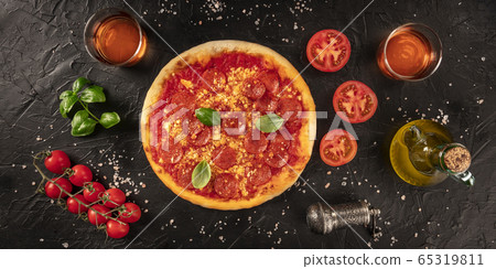 Pepperoni pizza panorama on a dark background, with wine and ingredients, tomatoes, basil, and olive oil, overhead shot 65319811