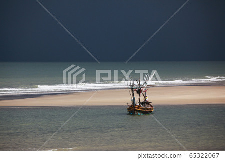 Thai fishing boat moored in a pool of tides at low tide 65322067