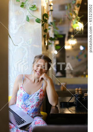 Female european student sitting at cafe and working by laptop. Female european student sitting at cafe and working by laptop. 65323002