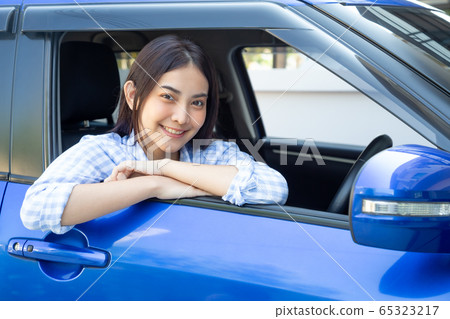 Asian women driving a car and smile happily with 65323217