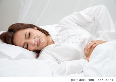 Young Asian woman suffering from abdominal pain or Young Asian woman suffering from abdominal pain or 65323874