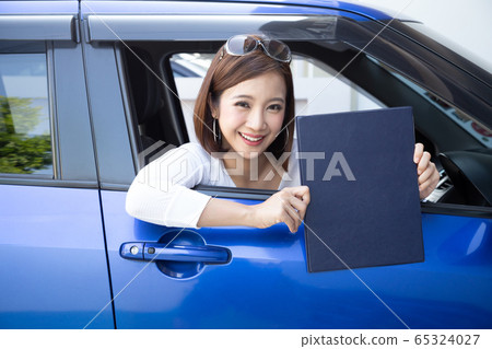 Happy Asian woman holding car insurance document Happy Asian woman holding car insurance document 65324027