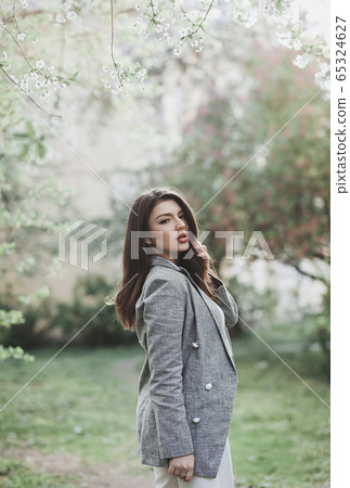 l happy smiling lady posing near flowering tree 65324627