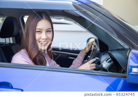Asian women driving a car and smile happily with Asian women driving a car and smile happily with 65324745