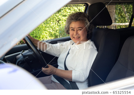 Asian senior women driving a car and smile happily 65325554
