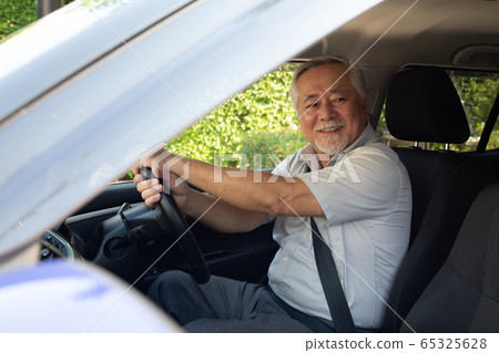 Asian senior men driving a car and smile happily Asian senior men driving a car and smile happily 65325628