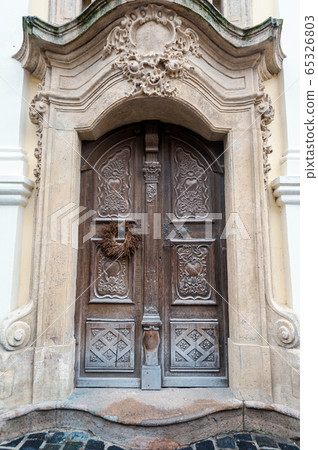 Old wooden door close-up on a background of a wall Old wooden door close-up on a background of a wall 65326803