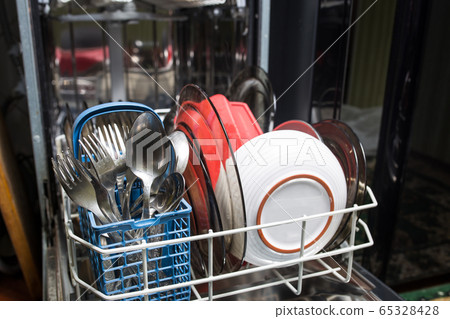 Dishwasher with dirty dishes closeup. Household kitchen appliances. Assistant hostess. Dishwasher with dirty dishes closeup. Household kitchen appliances. Assistant hostess. 65328428
