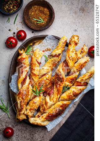 Crispy bread sticks with cheese, bacon and spices. 65328747