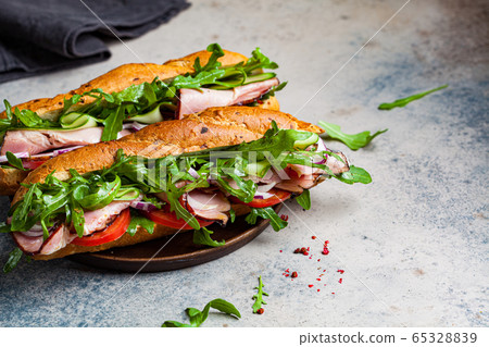 Two baguette sandwiches with meat, tomato Two baguette sandwiches with meat, tomato 65328839