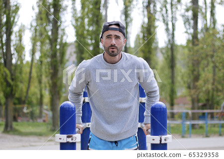 strong man on the bars making exercises 65329358