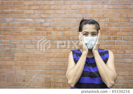 The hand holding the mask on Asian woman face 65330258