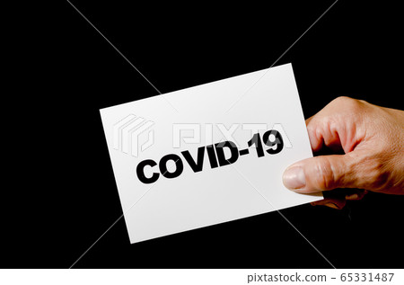 Hand holding a card written COVID-19 Hand holding a card written COVID-19 65331487