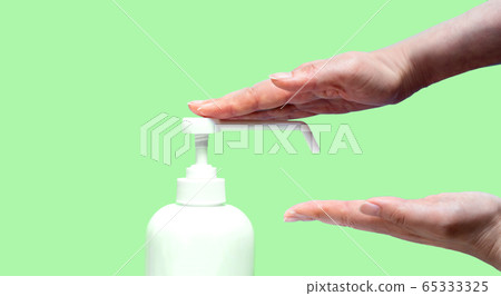 婦女的手,消毒瓶,複製空間和黃綠色背景婦女對其手進行消毒的地方 婦女的手,消毒瓶,複製空間和黃綠色背景婦女對其手進行消毒的地方 65333325
