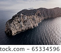 Aerial view on beautiful white Lighthouse of Cap de Formentor in the Coast of North Mallorca, Spain Balearic Islands at sunset. Wide view of wild rocky cliffs. 65334596