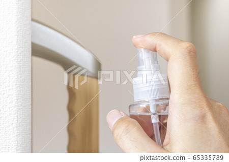 一名男子用消毒噴霧劑對室內扶手進行消毒 65335789