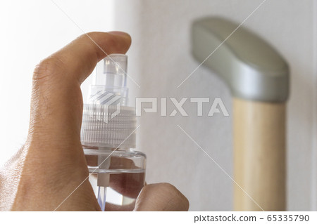 一名男子用消毒噴霧劑對室內扶手進行消毒 65335790