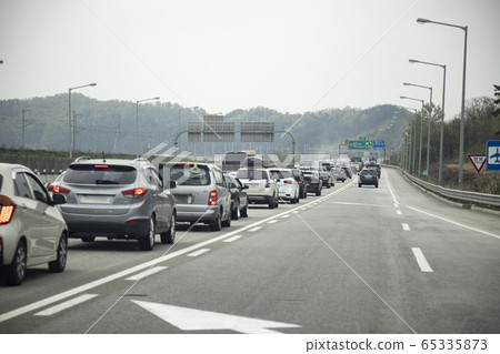 Vehicles moving slowly on a congested highway Vehicles moving slowly on a congested highway 65335873