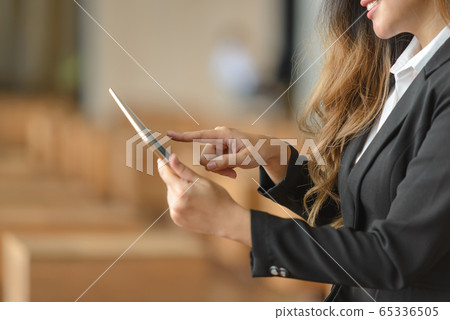 Close-up of businesswoman using a digital tablet 65336505