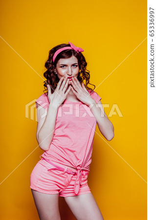 Portrait of a beautiful fashionable pinup woman with pink clothes 65336997