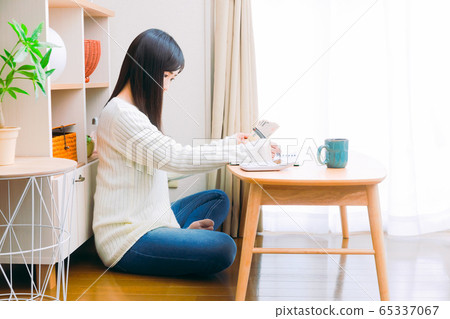 一個女人手裡拿著現金,一本手寫的家庭賬簿,一個生計管理副本空間填寫筆記本 一個女人手裡拿著現金,一本手寫的家庭賬簿,一個生計管理副本空間填寫筆記本 65337067