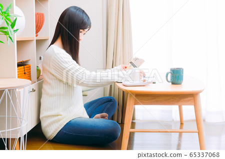 一個女人手裡拿著現金,一本手寫的家庭賬簿,一個生計管理副本空間填寫筆記本 一個女人手裡拿著現金,一本手寫的家庭賬簿,一個生計管理副本空間填寫筆記本 65337068