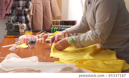 Business woman seamstress works in the workshop creating clothes 65337187