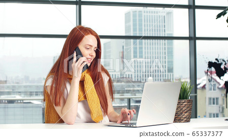 The girl is studying the latest news, browsing the Internet and talking on the phone 65337377