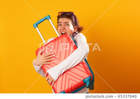 Woman with suitcase on orange background. Woman with suitcase on orange background. 65337840